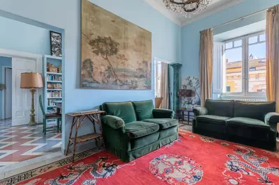 a living room with two green couches and a red rug at Residenza Prati - ZEN24 in Rome