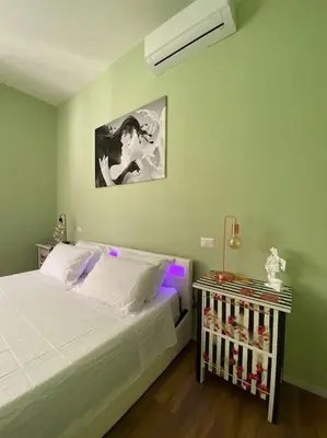 a bedroom with a white bed and a night stand at Carpegna42 in Rome
