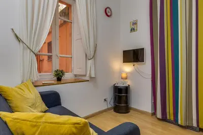 a living room with a blue couch and a window at Gladiator's House in Rome