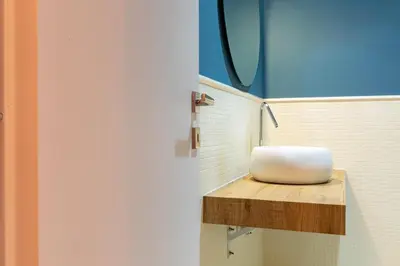 a bathroom with a white sink on a wooden shelf at Rdr Tortona Rooms in Rome