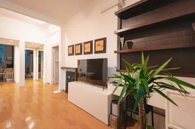 a living room with a large television and a plant at Rdr Tortona Rooms in Rome