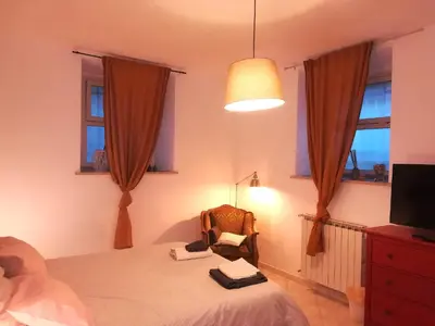 a bedroom with a bed and a chair and a television at I Colori di Nini Vacanza a Trastevere in Rome