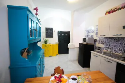 a kitchen with blue cabinets and a wooden table at I Colori di Nini Vacanza a Trastevere in Rome