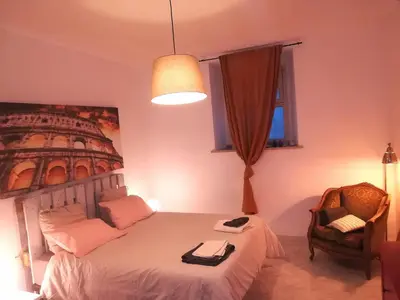 a bedroom with a bed and a chair and a lamp at I Colori di Nini Vacanza a Trastevere in Rome