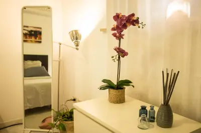 a bathroom with a table with a vase with flowers on it at I Colori di Nini Vacanza a Trastevere in Rome