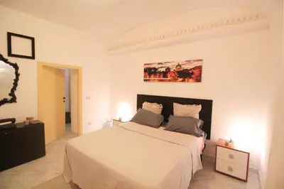 a white bedroom with a large bed with white sheets at I Colori di Nini Vacanza a Trastevere in Rome