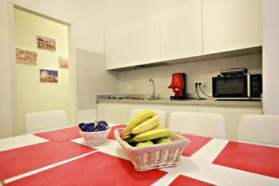 a kitchen with a table with a basket of bananas at Le Piazze Di Roma in Rome