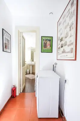 a white refrigerator in a room with a hallway at Trastevere Charming Retreat on Cobblestone Street in Rome
