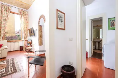 a living room with white walls and a white refrigerator at Trastevere Charming Retreat on Cobblestone Street in Rome
