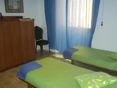 a room with two beds and a dresser and a window at Il Pretoriano in Rome