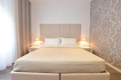 a bedroom with a large bed with two lamps at Maison Flaminio in Rome