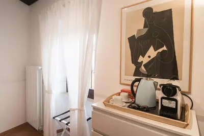 a room with a table with a picture on the wall at Casa Q163A Tuscolana Next to Metro in Rome