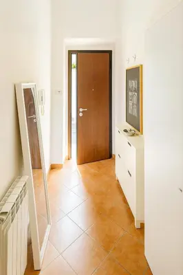 a hallway with a wooden door and a tiled floor at Casa Q163A Tuscolana Next to Metro in Rome