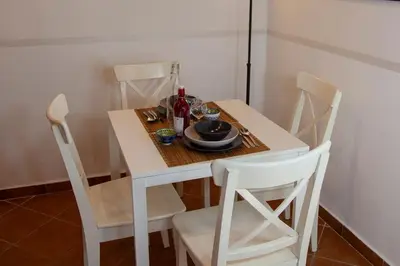 a white dining room table with white chairs and a white table and chairsktop at Casa Q163A Tuscolana Next to Metro in Rome