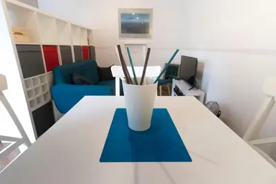 a white table with a vase with sticks on it at Casa Q163A Tuscolana Next to Metro in Rome