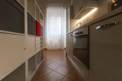 a kitchen with a hallway with a stove and cabinets at Casa Q163A Tuscolana Next to Metro in Rome