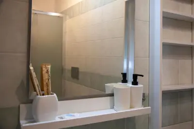 a bathroom with a mirror and a shelf with toiletries at Casa Q163A Tuscolana Next to Metro in Rome
