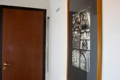 a hallway with a door with pictures on the wall at Casa Q163A Tuscolana Next to Metro in Rome