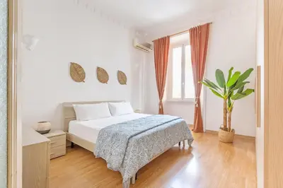 a white bedroom with a bed and a potted plant at Cactus2023 in Rome