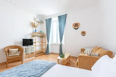 a bedroom with a bed and a couch and a tv at Cactus2023 in Rome