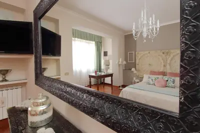 a mirror in a bedroom with a bed and a window at Beautiful apartment with amazing Rooftop&Jacuzzi in Rome