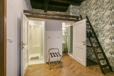 a bathroom with a staircase and a chair in a room at Trevi Little Palace #4 in Rome