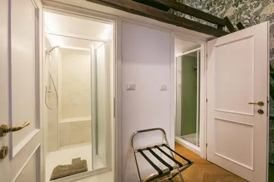 a bathroom with a walk in shower next to a glass door at Trevi Little Palace #4 in Rome