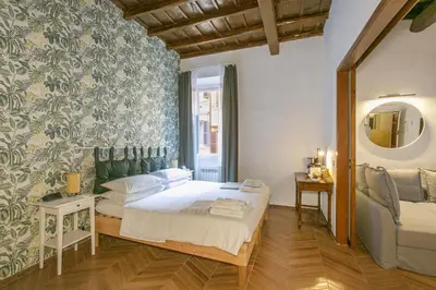 a bedroom with a bed and a couch and a mirror at Trevi Little Palace #4 in Rome