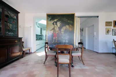 a dining room with a table and a painting on the wall at Anita in Rome