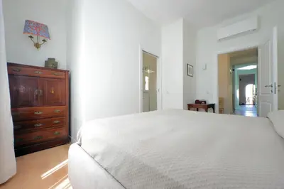 a bedroom with a white bed and a wooden dresser at Anita in Rome