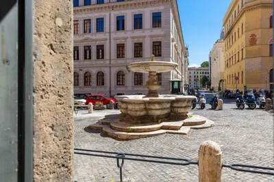 a fountain in the middle of a city street at RomeInSuite in Rome