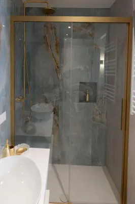 a shower with a glass door next to a sink at RomeInSuite in Rome