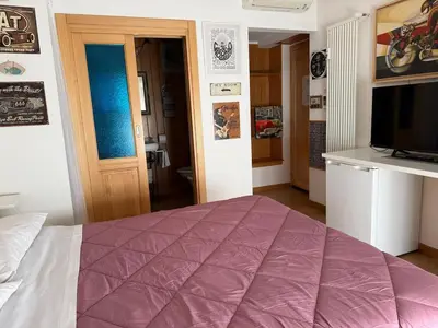 a bedroom with a purple bed and a television at Appartamento Garbatella in Rome