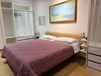 a bedroom with a purple bed with a painting on the wall at Appartamento Garbatella in Rome