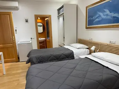 a hotel room with two beds and a painting on the wall at Appartamento Garbatella in Rome