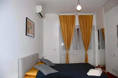 a bedroom with a bed and a window with orange curtains at LOCAZIONE TURISTICA PAOLUCCI in Rome