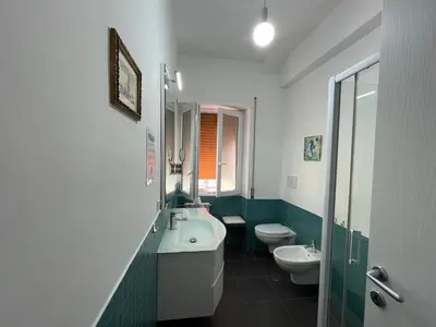 a green and white bathroom with two toilets and a sink at LOCAZIONE TURISTICA PAOLUCCI in Rome