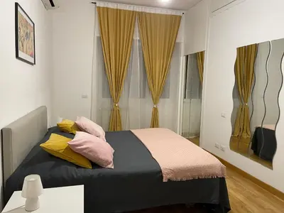 a bedroom with a bed with pink and yellow pillows at LOCAZIONE TURISTICA PAOLUCCI in Rome