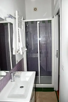 a bathroom with a sink and a shower with purple tiles at LOCAZIONE TURISTICA PAOLUCCI in Rome