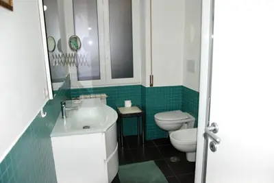 a bathroom with a sink and a toilet and green tiles at LOCAZIONE TURISTICA PAOLUCCI in Rome