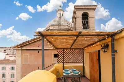 a balcony with a table and a building with a tower at Rooftop Colosseum in Rome