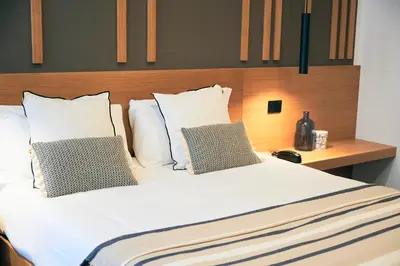 a large bed with white sheets and pillows at Central Lodge Hotel in Rome