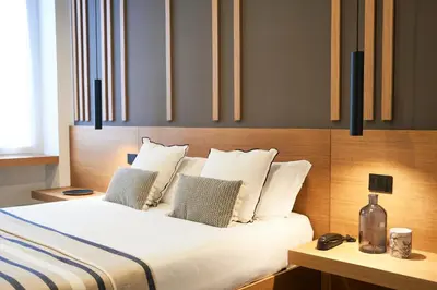 a bedroom with a bed with white sheets and pillows at Central Lodge Hotel in Rome