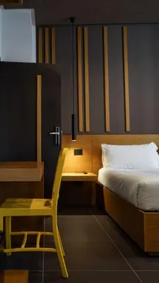 a bedroom with a bed and a desk and a chair at Central Lodge Hotel in Rome