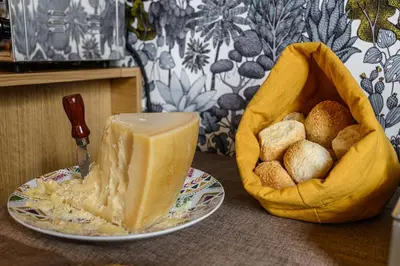 a plate with a piece of cheese and a basket of bread at Central Lodge Hotel in Rome