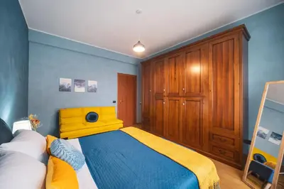 a bedroom with a yellow bed and wooden cabinets at Marconi 31 Rome Holiday House - Rome Vacation M&D in Rome