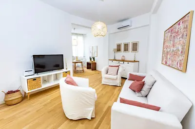 a living room with white furniture and a flat screen tv at Noh collection 3BDR apartment- Trastevere Area in Rome