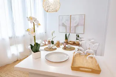 a white table with flowers and glasses on it at Noh collection 3BDR apartment- Trastevere Area in Rome