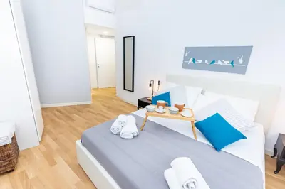 a white bedroom with a bed and a table at Noh collection 3BDR apartment- Trastevere Area in Rome