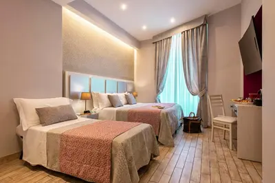 a hotel room with two beds and a window at Five Rooms Rome Guesthouse in Rome